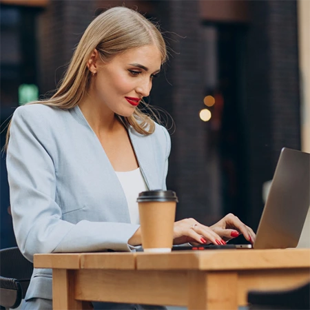 Female professional working on a laptop, accessing documents through a centralized document management system